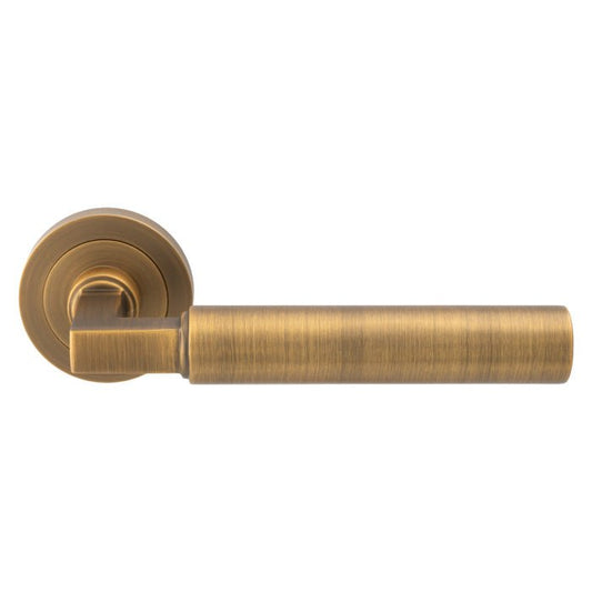 Carlisle Brass Amiata Lever On Round Rose featuring a brushed antique brass finish, designed with a cylindrical lever and a round rosette for a sleek and modern look.