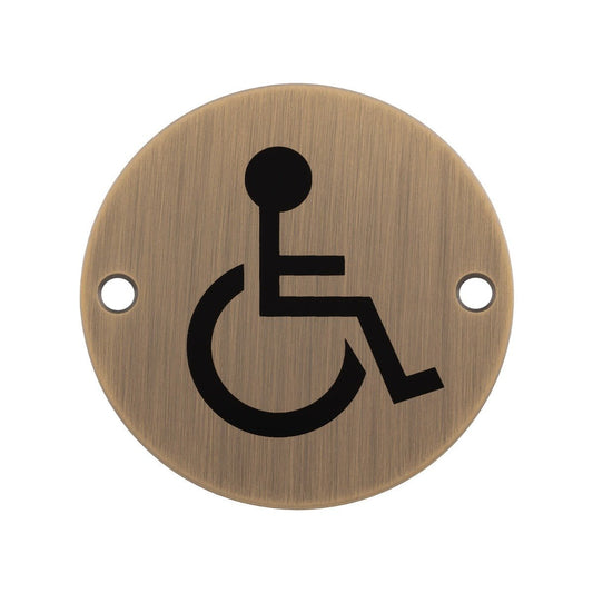 Carlisle Brass Disabled Symbols sign in brushed brass finish, featuring a black wheelchair symbol, with two holes for mounting.