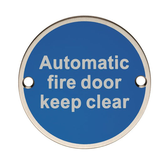 Carlisle Brass Automatic Fire Door - Keep Clear sign in a circular shape, featuring a blue background with white text, made from durable material with two mounting holes.