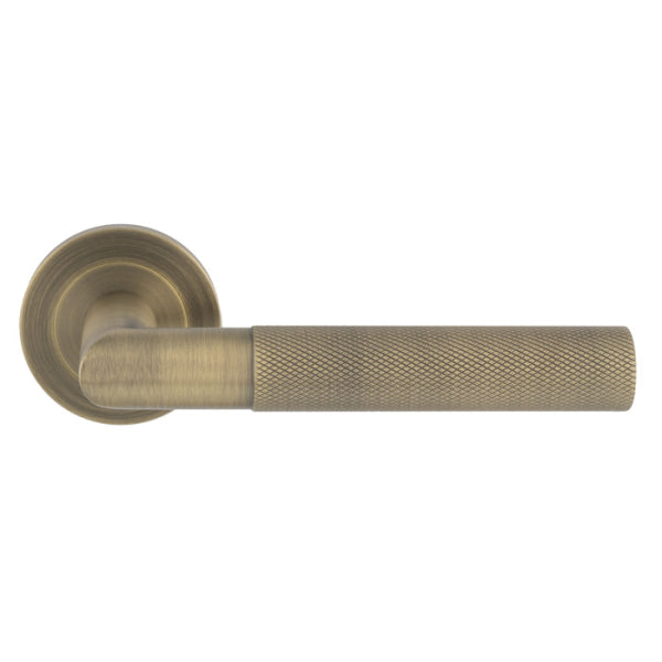 Carlisle Brass Crown Knurled Lever in antique brass finish, featuring a knurled grip texture and a round rose base for mounting.